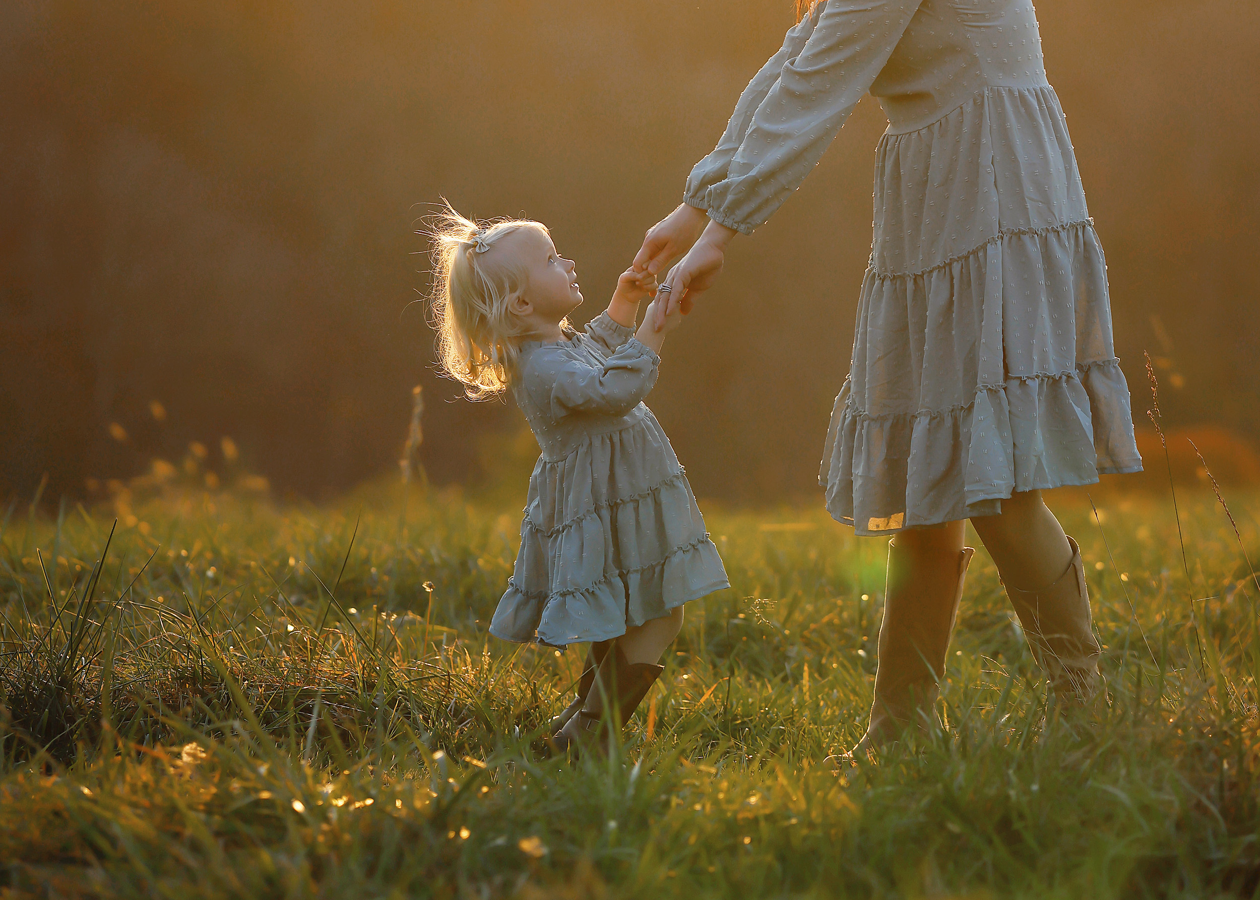 Mother and child walking through a field during a sunset farmstay photo session in North Carolina